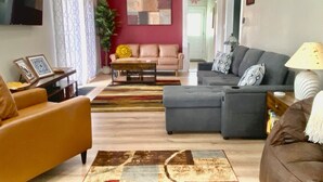 Un salon avec un canapé, un fauteuil et une table basse.