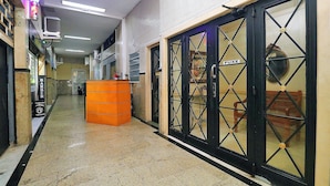 A hallway with a tiled floor, a large orange counter, and a door labeled "PAXE". - Quarto & Sala a 150m da Praia U052 (Rio de Janeiro)