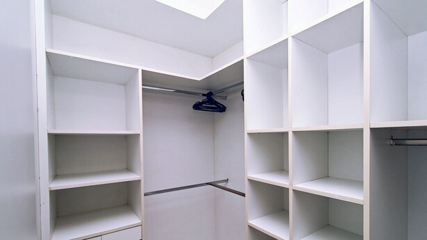 A walk-in closet with multiple shelves and hanging space. - Quarto & Sala a 150m da Praia U052 (Rio de Janeiro)