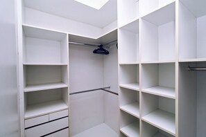 A walk-in closet with multiple shelves and hanging space. - Quarto & Sala a 150m da Praia U052 (Rio de Janeiro)