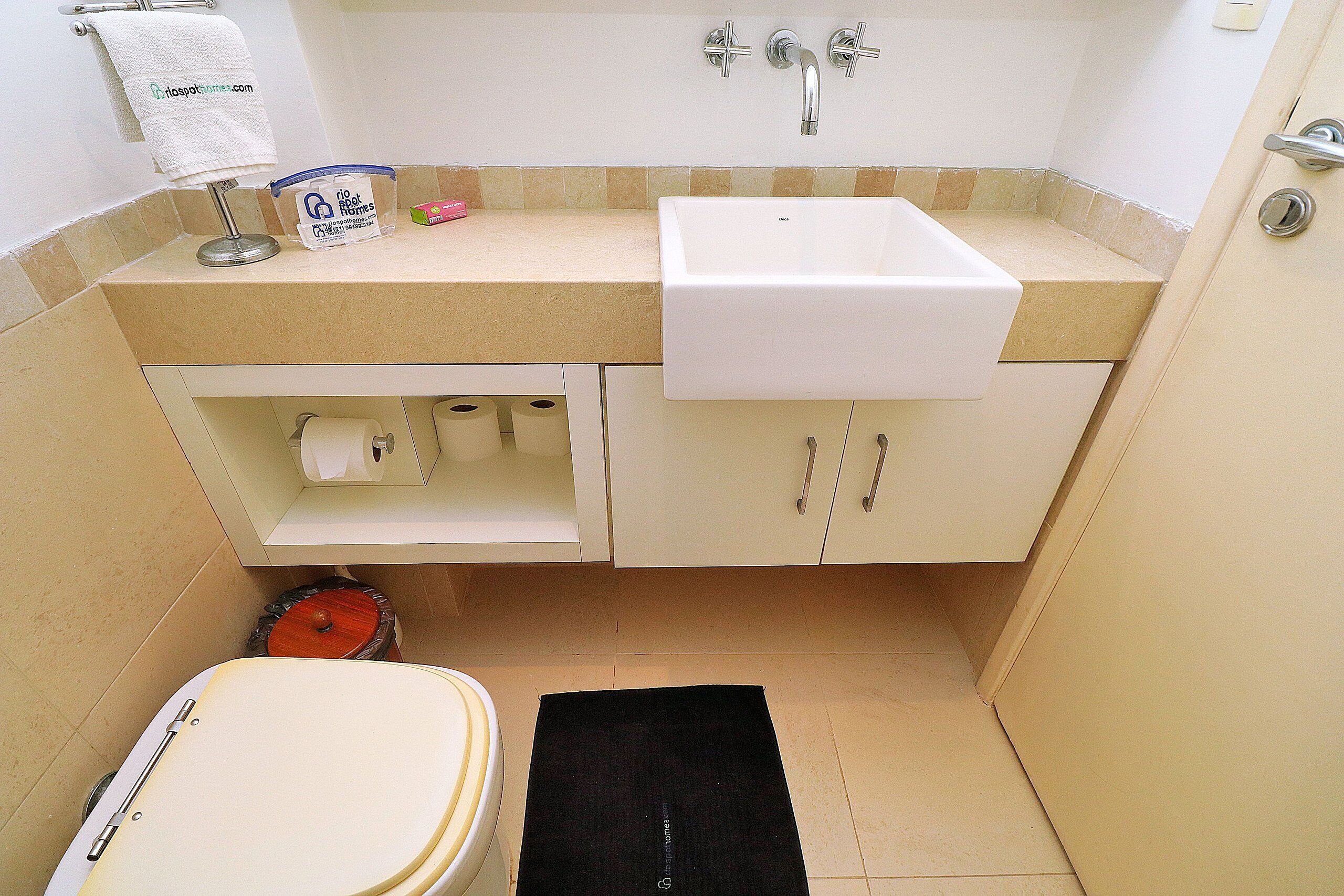 Une petite salle de bain comprenant des toilettes, un lavabo et un meuble de rangement.