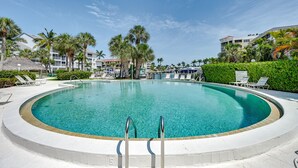 A circular pool with clear water, surrounded by palm trees and lounge chairs. - Waterfront Marco Island Condo < 1/4 Mi to Beach! (Marco Island)