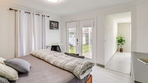 A bedroom with a bed, a desk, a chair, a potted plant, and a sliding glass door leading to a balcony. - Riverfront Tennessee Retreat w/ Patio & Boat Ramp! (Elizabethton)