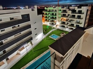 Enjoy a refreshing dip in the rooftop pool surrounded by lush greenery and palm trees.