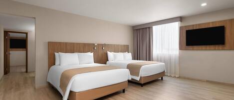 A hotel room with two beds, a flat-screen TV mounted on the wall, and a wooden floor.