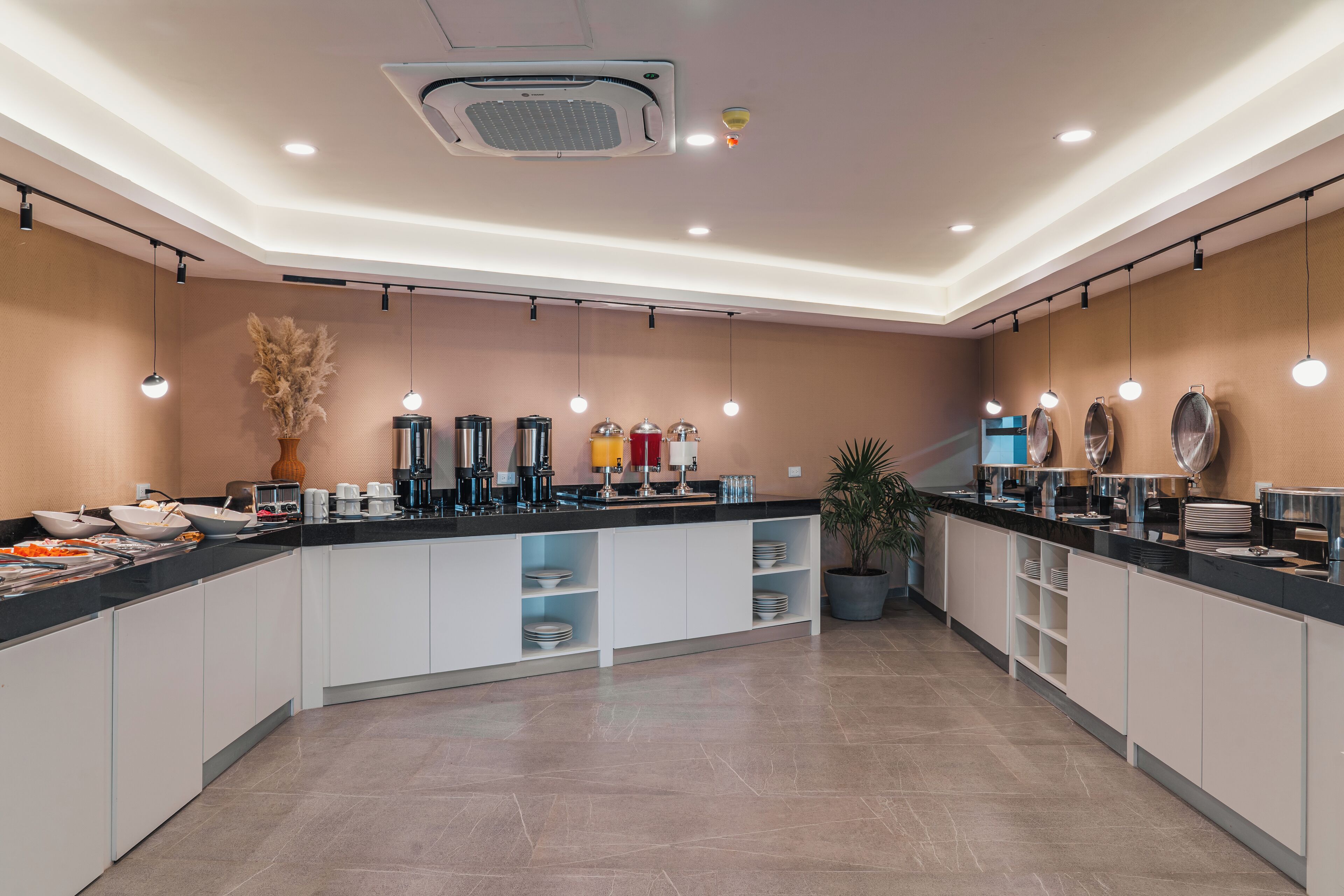 Uma cozinha moderna com ilha central, eletrodomésticos embutidos e iluminação pendente.