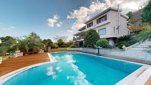 Enjoy a relaxing stay in this two-story house with a spacious backyard featuring a rectangular swimming pool and beautifully landscaped gardens.