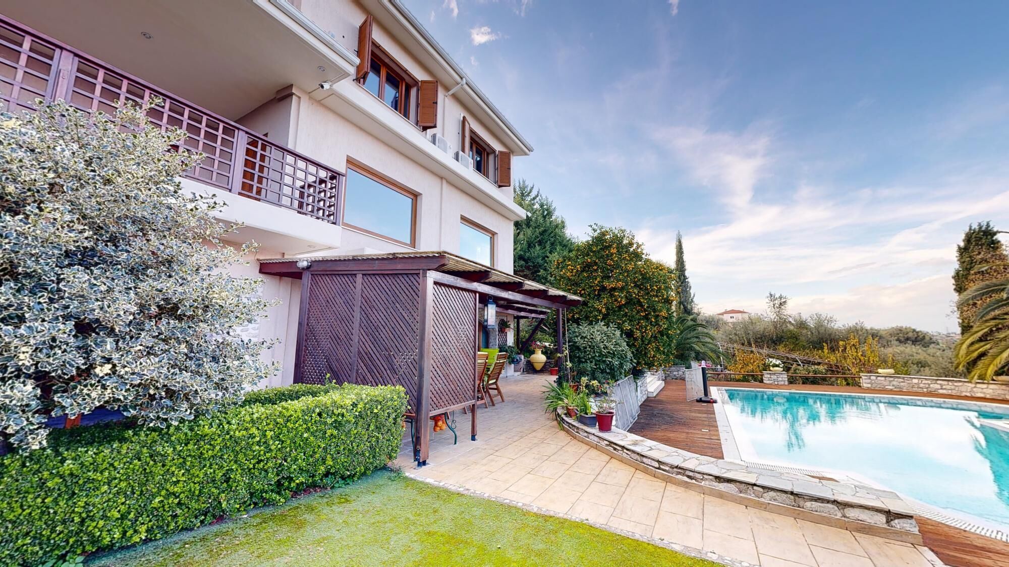 A modern two-story house with a swimming pool, a covered patio, and a well-maintained garden.