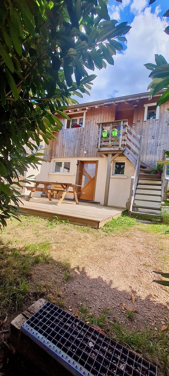 A wooden house with a balcony and a wooden deck.