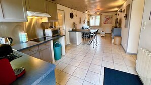 Une cuisine compacte équipée d’un four à micro-ondes, d’une cuisinière et d’un petit coin repas avec des chaises.