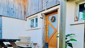 Une terrasse en bois avec un panneau indiquant la direction de la « Forêt enchantée » et du « Lac gelé ».