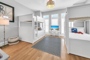 A bedroom with a bunk bed, a desk with a computer, and a window with a view of the sea. - Lily Pad (Panama City Beach)