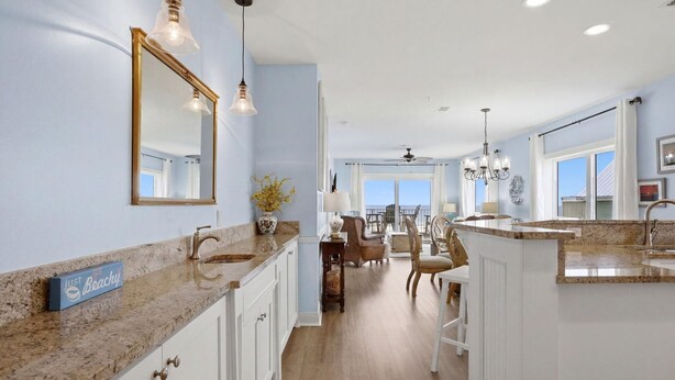 A spacious kitchen with granite countertops, white cabinetry, and pendant lighting. - Riviera Dunes 203 (Pensacola)