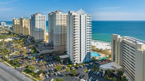 A high-rise hotel with multiple floors, a swimming pool, and a view of the ocean. - Palacio 1202 (Pensacola)