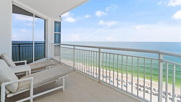 A balcony with two lounge chairs and a view of the beach and ocean. - Palacio 1202 (Pensacola)