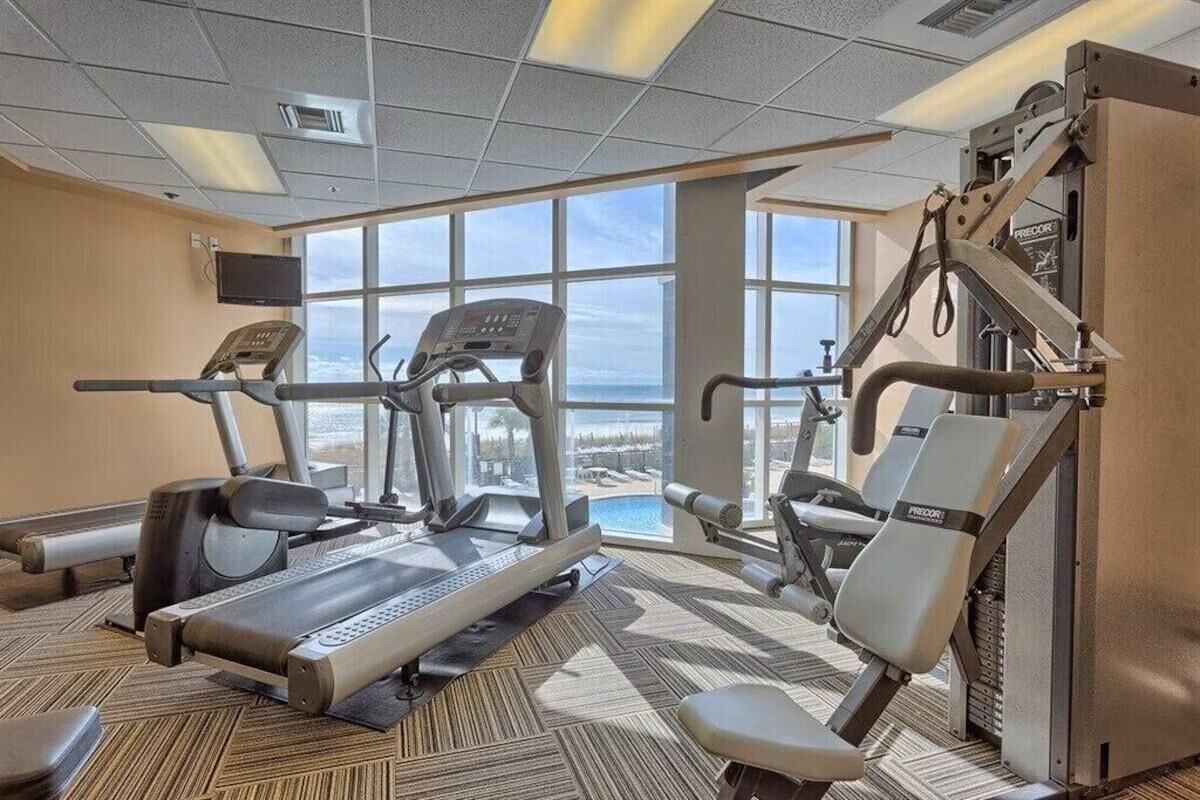 A gym with treadmills, elliptical machines, and weightlifting equipment.