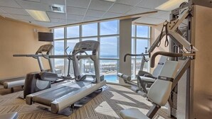 A gym with treadmills, elliptical machines, and weightlifting equipment. - Palacio 1202 (Pensacola)