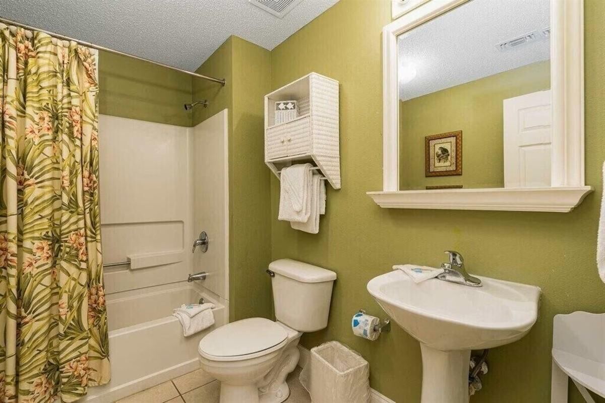 Une salle de bain avec des toilettes, un lavabo et une douche.