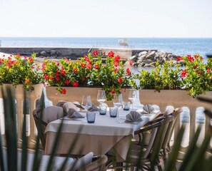Un área de comedor al aire libre con una mesa preparada para dos, con vista al mar.