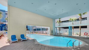 Ein Swimmingpool mit blauen Stühlen, einem Balkon und einem Rettungsring.