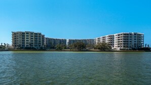 Ein Hotel am Wasser mit mehreren Stockwerken und Balkonen, das ein modernes architektonisches Design aufweist.