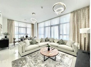 Relax in this stylish living room with a large sofa, coffee table, and dining area.