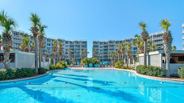 Una piscina rodeada de palmeras y edificios modernos.