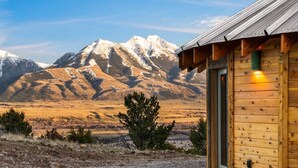A wooden cabin with a door, a window, and a light fixture. - Mountain Yurt: Luxe Yellowstone Cabin | Condé Nast (Emigrant)
