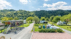 A campground with RVs, tents, and a playground area.