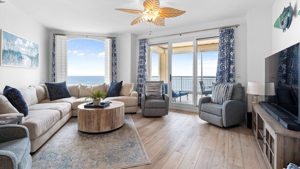 A modern living room with a sofa, armchairs, a coffee table, and a TV. - Beach Colony West 4B (Pensacola)