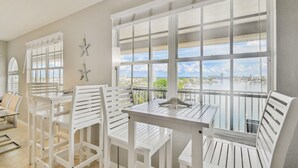 A balcony with white furniture and a view of a cityscape and water.