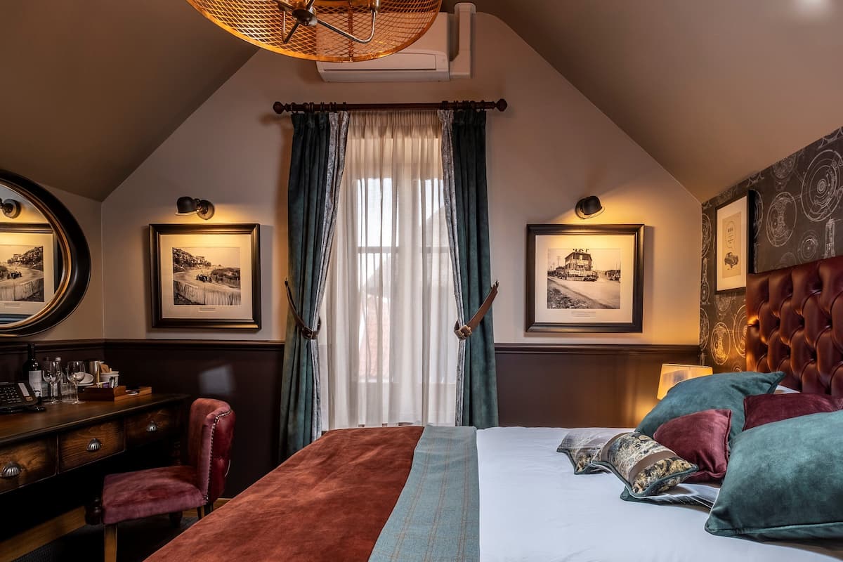 Une chambre à coucher avec un lit, un bureau, une chaise et un miroir.