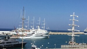 Un puerto deportivo con varios yates y un gran crucero amarrados.