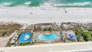 A resort with multiple swimming pools, a beach, and a view of the ocean.