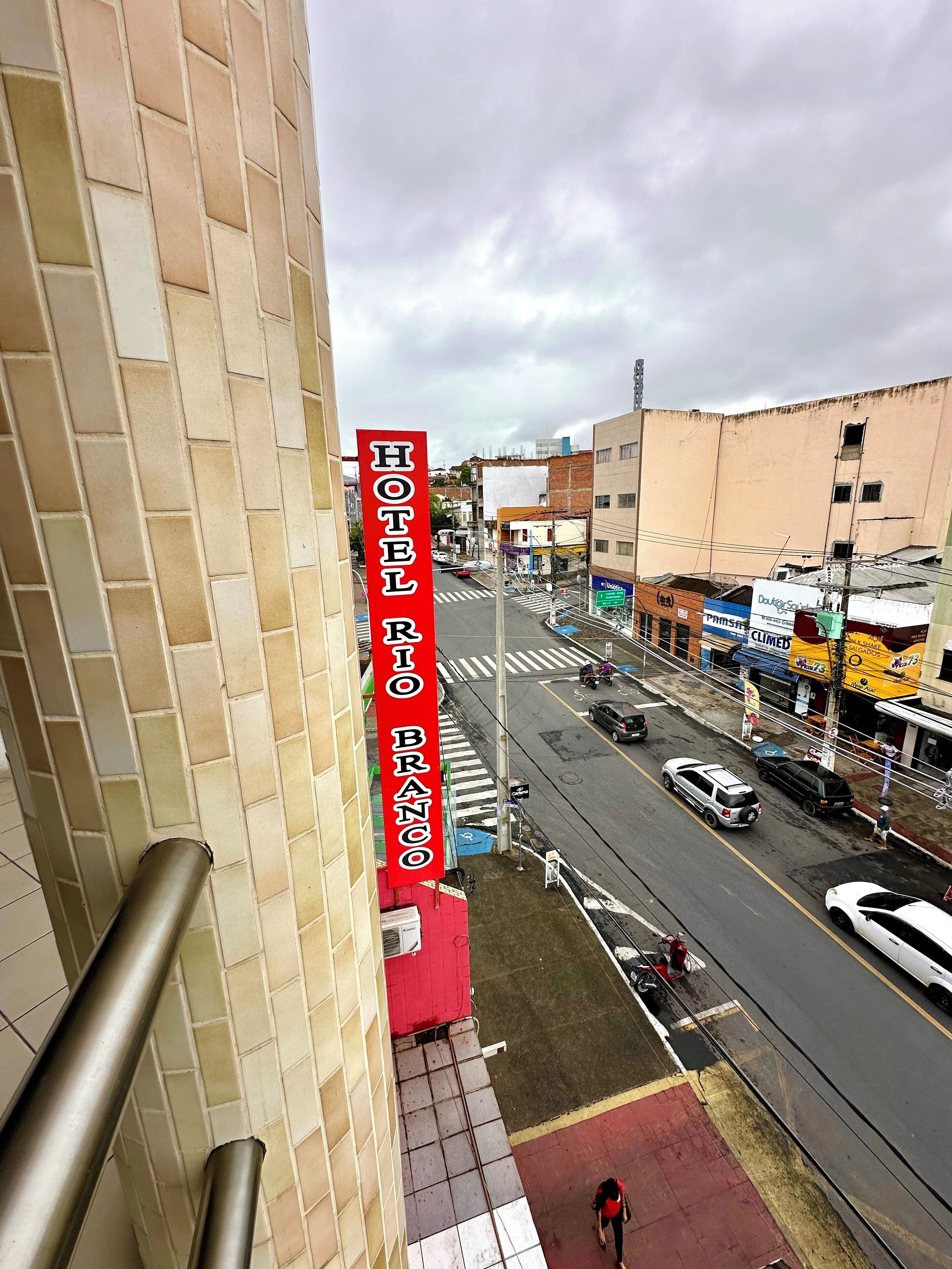 A hotel named "HOTEL BRUNO" with a view of a busy street and various shops.