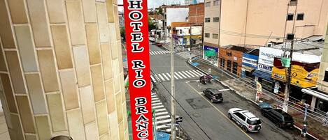 A hotel named "HOTEL BRUNO" with a view of a busy street and various shops.