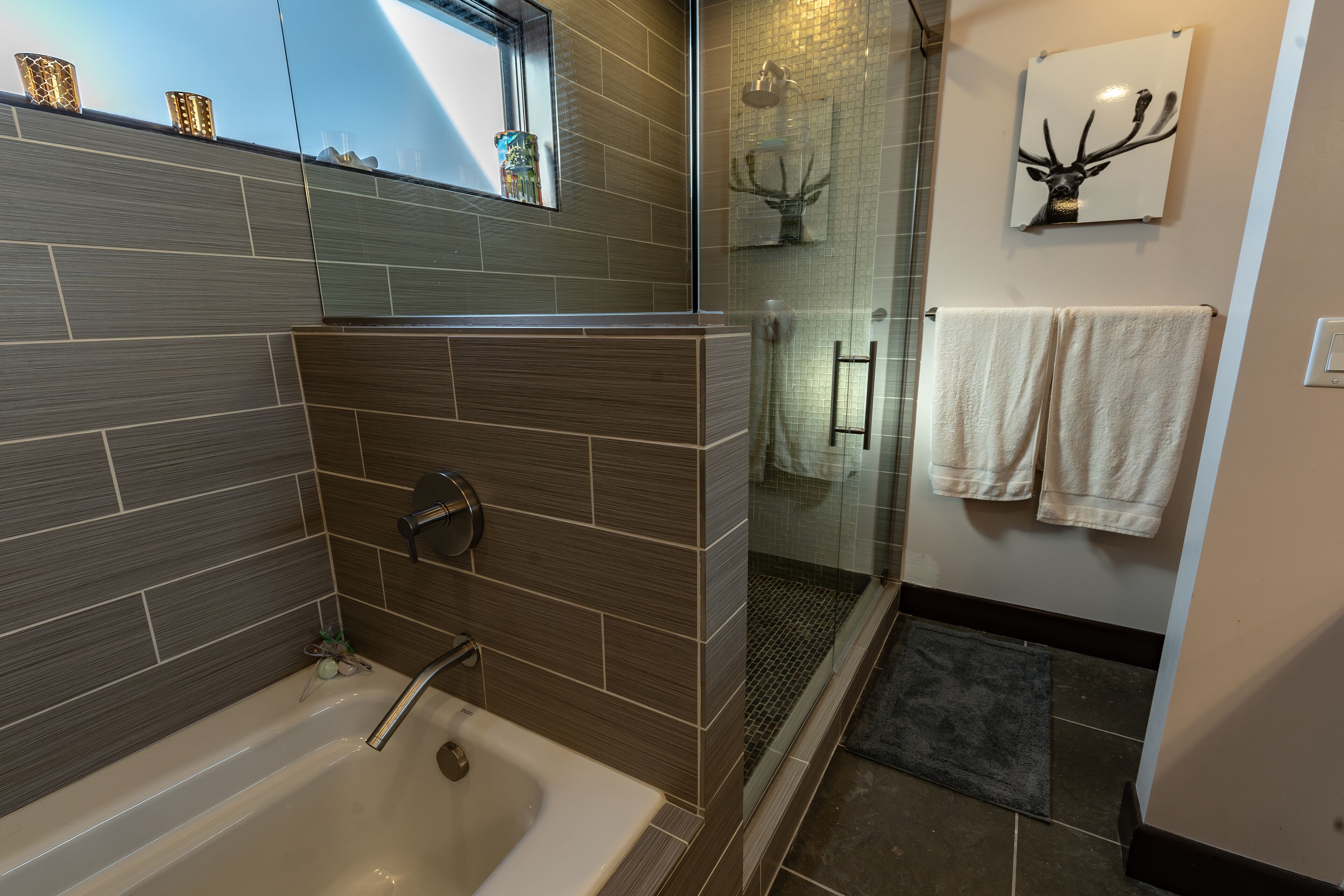 Un baño moderno con bañera, ducha y puerta de cristal.