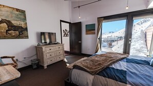 A bedroom with a bed, a dresser, a television, and a painting on the wall. - Pearl Penthouse by Jackson Vacations (Jackson)