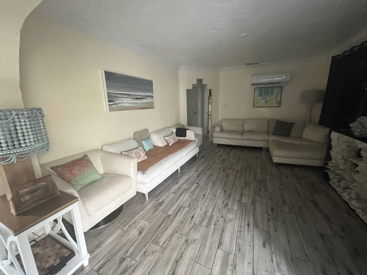 A living room with two sofas, a coffee table, and a painting on the wall.