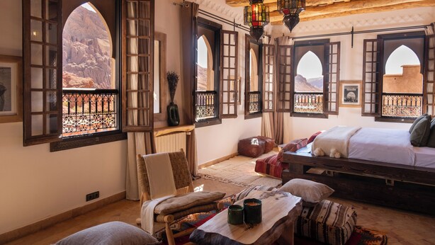 A room with a bed, a chair, and a table with a vase and a cup. - Eden Boutique Hotel (Ait Sedrate Jbel El Soufla)