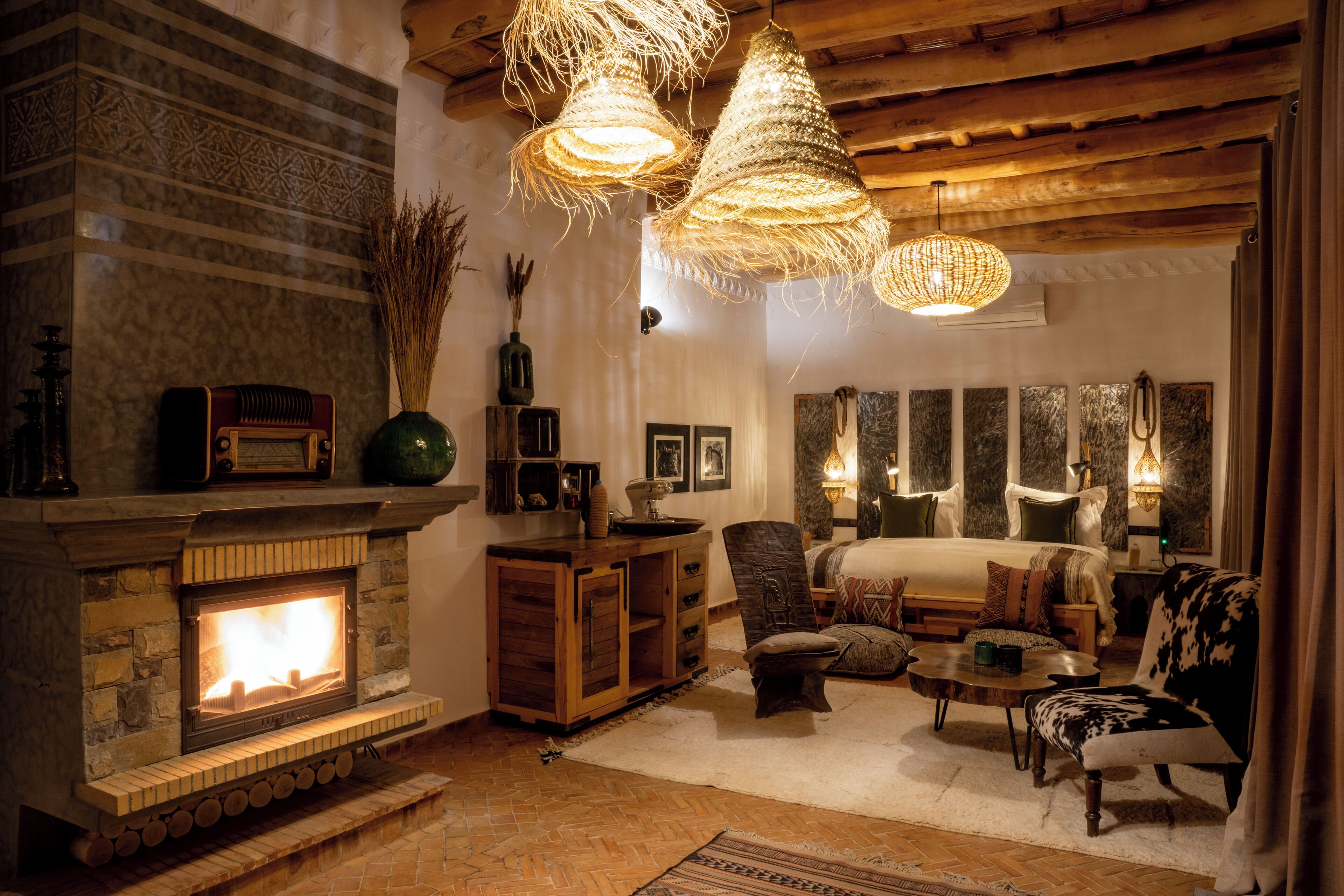 Un salon chaleureux avec une cheminée, des meubles en bois et des luminaires suspendus.