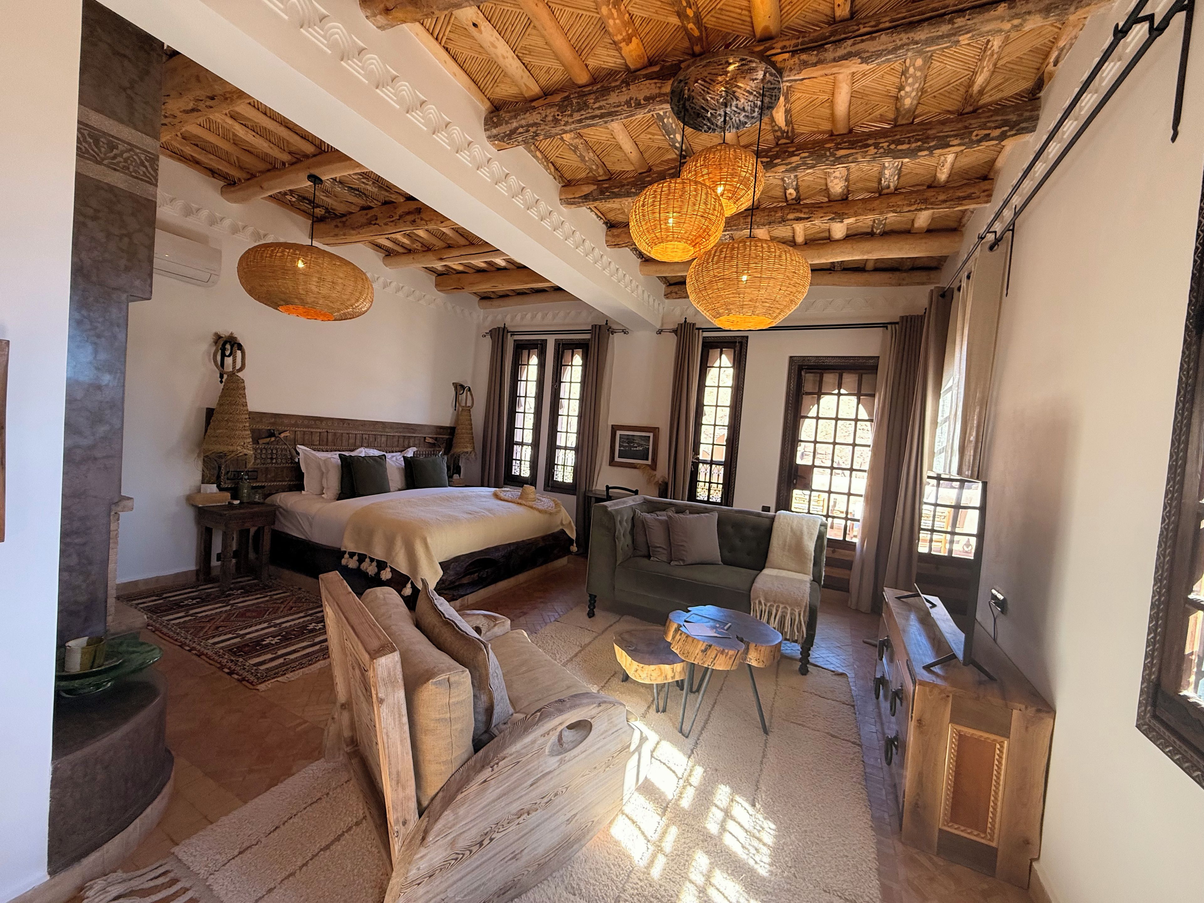 Une chambre à coucher comprenant un lit, un canapé, une table à manger et un lustre.