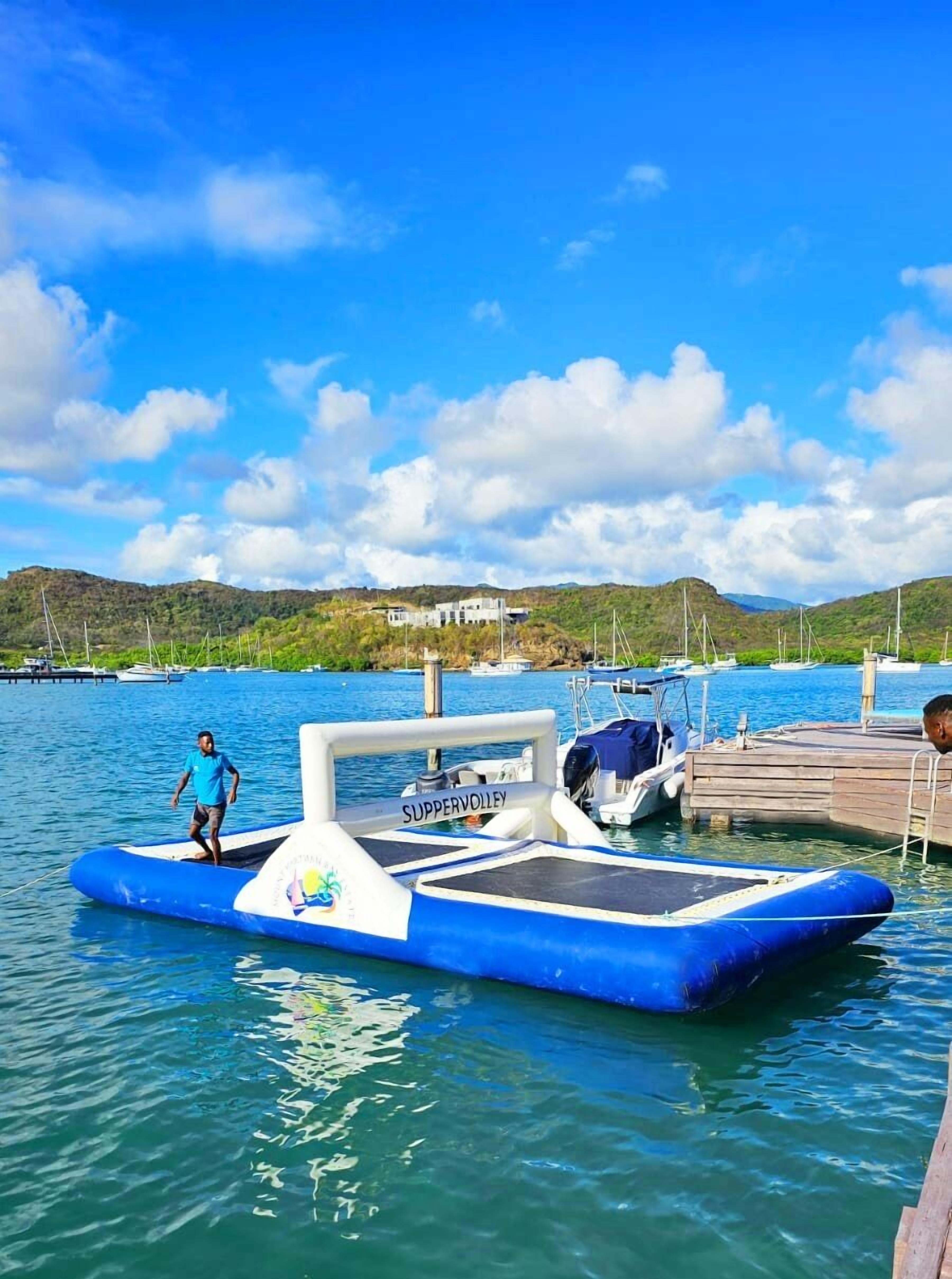 A SUPPERVOLLEY boat docked at a marina with a clear blue sky and calm water.