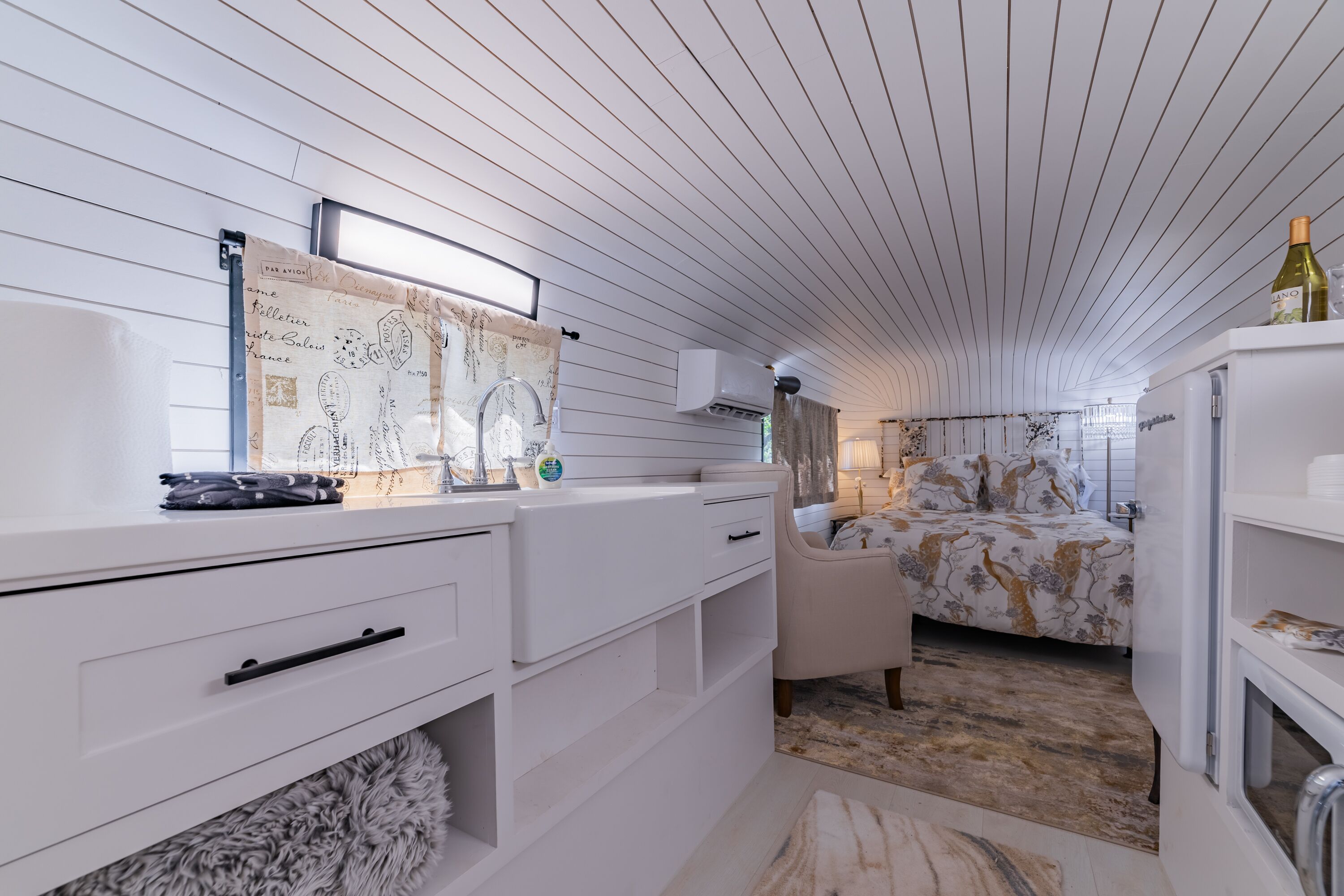 A modern bedroom with a bed, a nightstand, and a dresser.