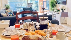 A breakfast setting with a coffee maker, croissants, and juice glasses on a table. - Beautifully presented 2 bedrooms apartment with a pool and garden view. (Paphos)