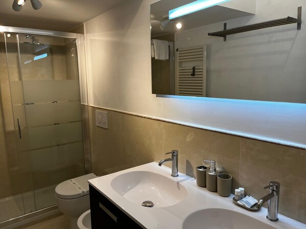 Een douche, een haardroger, een bidet, handdoeken