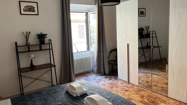 Une chambre moderne équipée d’un lit, d’un bureau, d’une chaise, d’un radiateur et d’une fenêtre avec des rideaux.