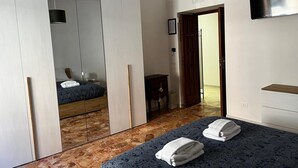Une chambre d’hôtel avec un lit, une armoire, un bureau et une télévision.