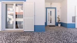 A building entrance with a tiled floor, a sliding glass door, and a potted plant. - Vivenda Duneta - in Walking Distance to the Beach by Lisbeyond (Aljezur)