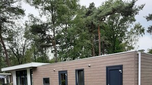 Un bâtiment moderne doté d’un toit plat, d’une cour clôturée et d’une pelouse bien entretenue.